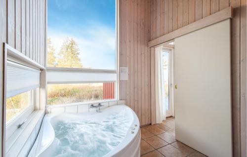 ein Bad mit einer Badewanne und einem großen Fenster in der Unterkunft Beautiful Home In Odder With Wifi in Odder