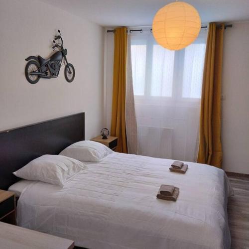 appartement 4 personnes, lumineux et standing في بريست: غرفة نوم مع سرير مع دراجة نارية على الحائط