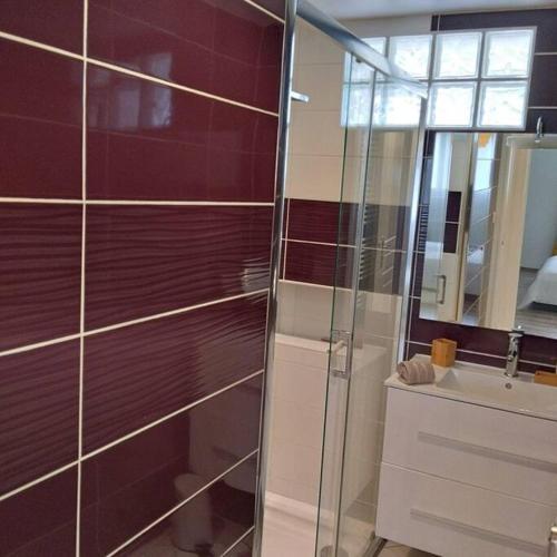 La salle de bains est pourvue d'une douche en verre et d'un lavabo. dans l'établissement appartement 4 personnes, lumineux et standing, à Brest