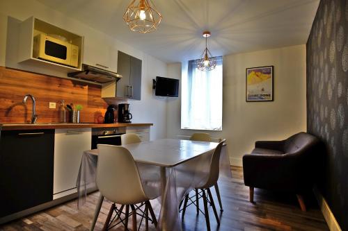 uma cozinha e sala de jantar com mesa e cadeiras em Villa Jean Julien - Le Guéry - Appartement T2bis - 2 chambres - 4 personnes em Le Mont-Dore