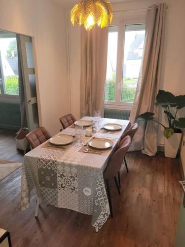 une salle à manger avec une table, des chaises et un lustre dans l'établissement maison 2 chambres spa centre ville spa, à Quimper