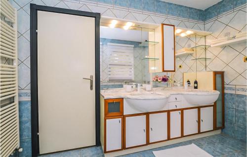 a bathroom with two sinks and a large mirror at Cozy Home In Jurdani With Heated Swimming Pool in Jurdani