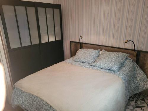 une chambre avec un lit avec deux oreillers dessus dans l'établissement maison 2 chambres spa centre ville spa, à Quimper