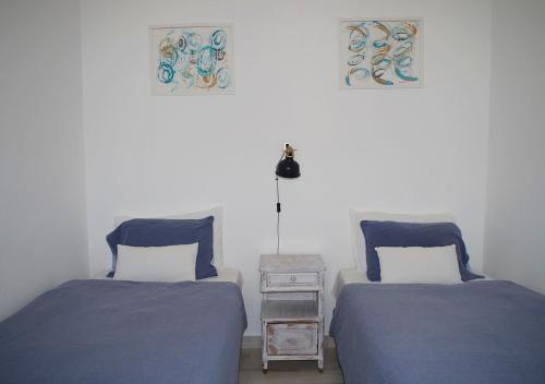 two beds sitting next to each other in a bedroom at Agapito's Houses in Praia de Odeceixe