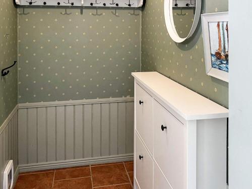 łazienka z białą szafką i lustrem w obiekcie Holiday home MUNSö w mieście Ekeby