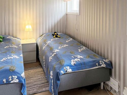 ein Schlafzimmer mit 2 Betten und einer blauen Bettdecke mit einer Ente oben in der Unterkunft Holiday home MUNSö in Ekeby