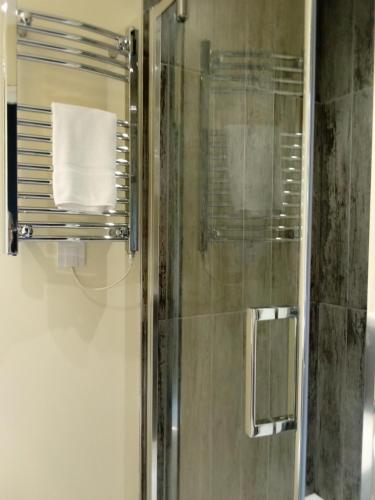 a bathroom with a shower with a glass door at The Church House in Torver