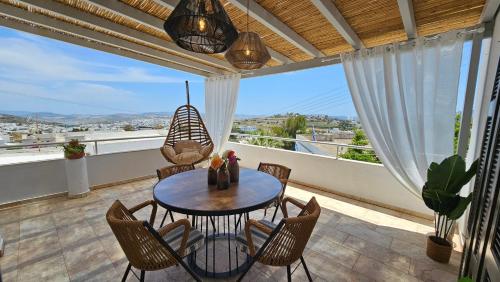 d'une terrasse avec une table et des chaises sur un balcon. dans l'établissement Plaka Philoxenia Apartments, à Plaka Milou