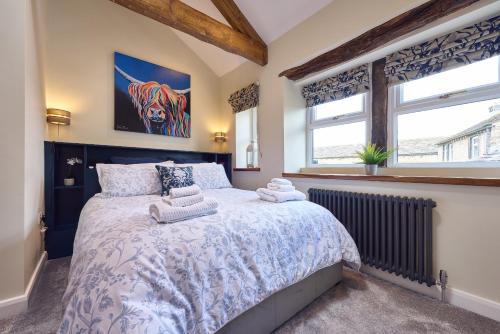 a bedroom with a large bed and a window at Chimney Cottage in Holmfirth