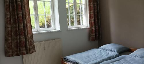 a bedroom with two beds and two windows at Eifelerlebnis in Jünkerath