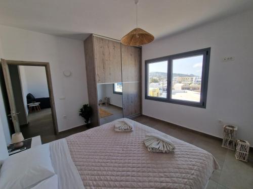 a bedroom with a large bed and a large window at Aerial Apartment in Karterados