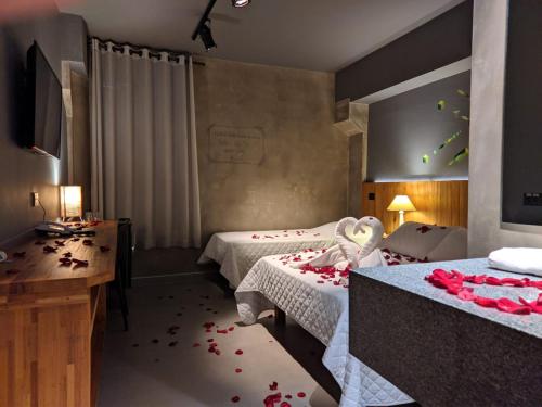 a hotel room with two beds with red roses on the floor at Villa'l Mare Hotel in Maresias