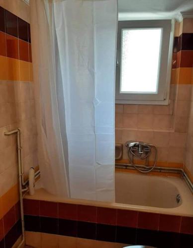 a bathroom with a bath tub with a window at Ammophila-Lemnos 1 in Mirina