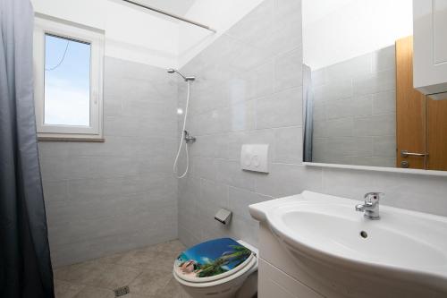 Apartments Ivan mit Meerblick في بومير: حمام مع حوض ومرحاض ومرآة