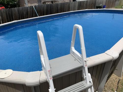 a white chair sitting next to a swimming pool at Bay View Bungalow by the Pier home in Norfolk