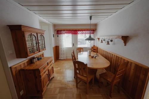 Granträsket的住宿－Family house in Swedish Lapland，一间带木桌和椅子的用餐室
