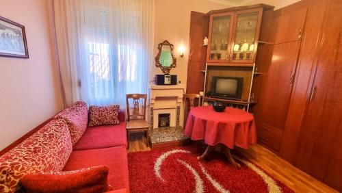 a living room with a red couch and a table at Liora's Place in Korçë