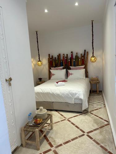 a bedroom with a white bed and a table at Riad Tsar Mimoun in Marrakesh