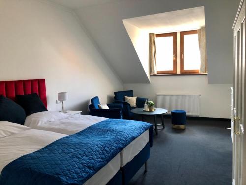a bedroom with a bed and a table and a window at Pension Drei Rosen in Karlovy Vary