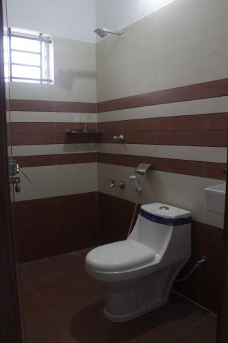 a bathroom with a white toilet and a shower at CITY APARTMENTS in Guruvāyūr