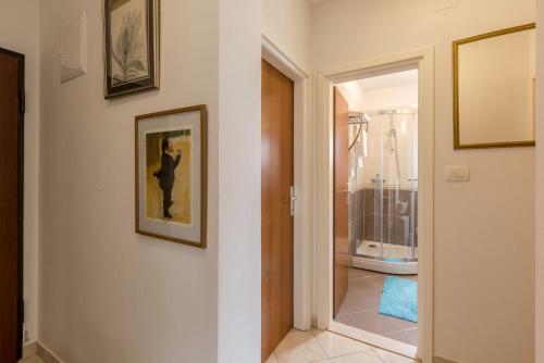 a hallway with a door to a bathroom with a shower at Apartment Zara with Free parking in Dugopolje