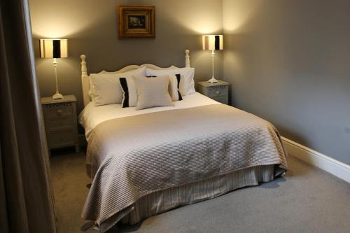 1 dormitorio con 1 cama grande y 2 mesitas de noche en The Barn @Bourne Eau House, en Bourne