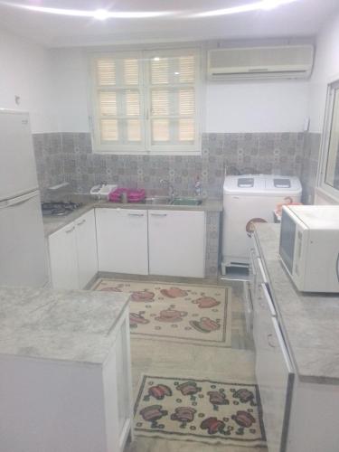 a kitchen with white cabinets and a counter top at Maison pieds dans l'eau in Sousse