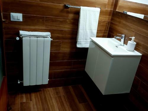 La salle de bains est pourvue d'un lavabo blanc et d'un radiateur blanc. dans l'établissement Borgo Saraceno Primo, à Sambuca di Sicilia