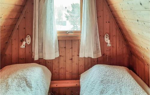 a bedroom with two beds in a wooden cabin at Amazing Home In Heggenes With 2 Bedrooms in Heggenes