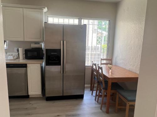 a kitchen with a stainless steel refrigerator and a table at UCLA Westwood in Los Angeles
