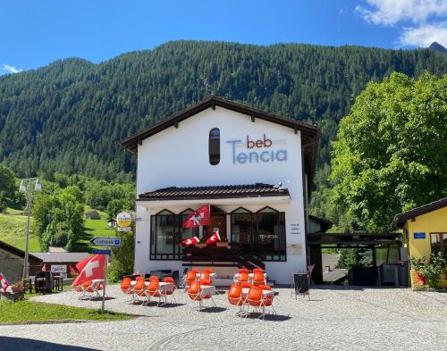 a building with tables and chairs in front of it at B&B Tencia in Prato