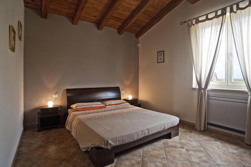a bedroom with a bed with two night stands and two windows at B&B Tocà la Louna in Vodnjan