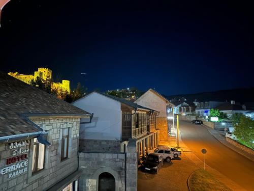 una strada di città di notte con auto parcheggiate sulla strada di Golden Gate a Akhaltsikhe