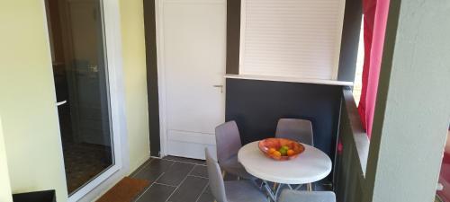 a small table and chairs with a bowl of fruit on it at LASYMPHO - Séjour de repos à la campagne in Le François