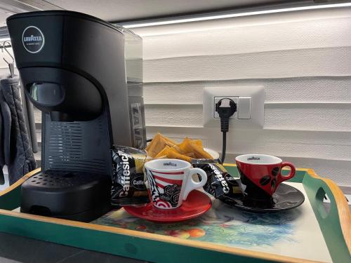 un plateau avec deux tasses à café et un micro-ondes dans l'établissement Il giardino dell'Etna, à Mascalucia