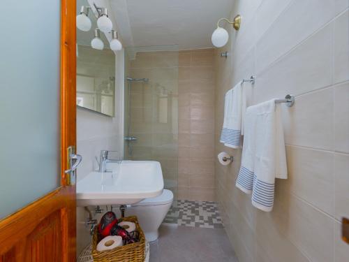 a bathroom with a white toilet and a sink at FAMILY COTTAGE AMONG OLIVE TREES in Agüimes