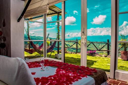 Zimmer mit einem Bett mit roten Rosen darauf in der Unterkunft GLAMPING PUNTA CAÑON in Villanueva