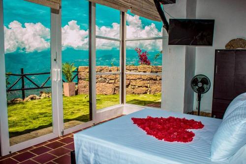 una camera da letto con un letto con fiori rossi di GLAMPING PUNTA CAÑON a Villanueva
