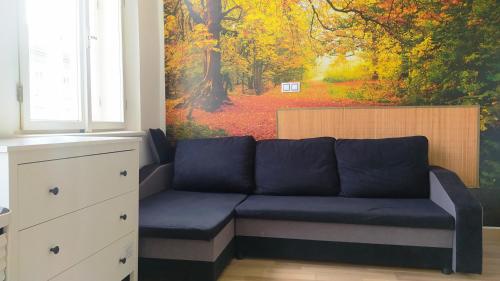 a blue couch in a room with a painting at LOVELY Prague Apartment in Prague