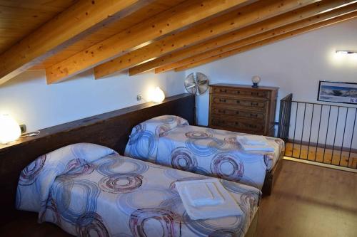 een zolderkamer met 2 bedden en een dressoir bij Balcony on Lake Pianello in Pianello Del Lario