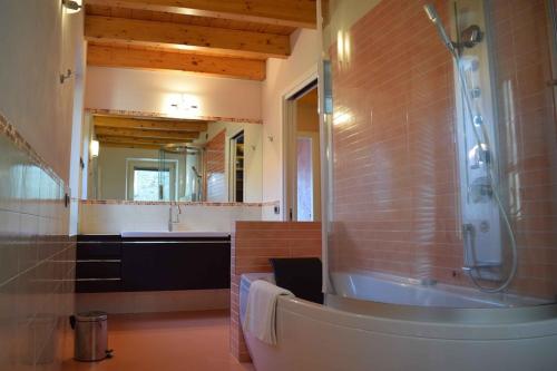 een badkamer met een douche, een wastafel en een bad bij Balcony on Lake Pianello in Pianello Del Lario