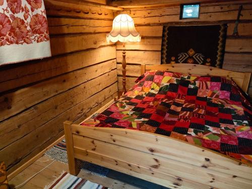 a bedroom with a bed in a log cabin at Reittiö B&B in Sulkava