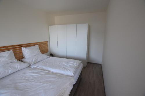 a bedroom with two beds with white sheets at Apartmán v LakeParku in Staré Splavy