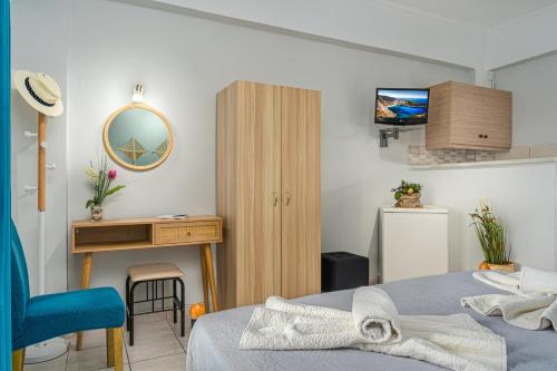 a bedroom with a bed and a desk and a mirror at Elena's Seafront Deluxe Studios in Zakynthos