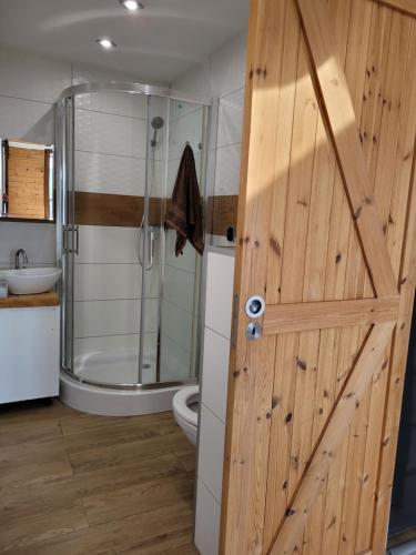 a bathroom with a shower and a wooden door at Widokowy Raj Piękny Widok!! in Międzybrodzie Bialskie