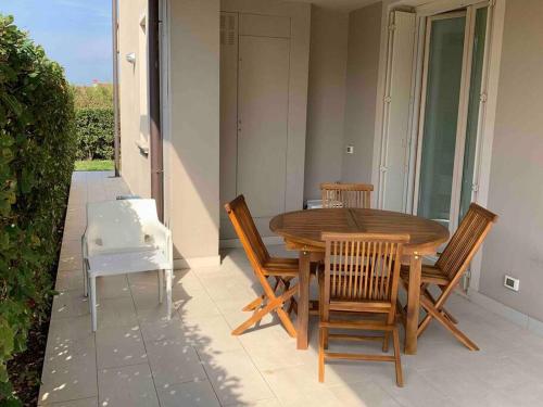 Una mesa y sillas de madera en un patio. en Residenza Puccini, en Desenzano del Garda