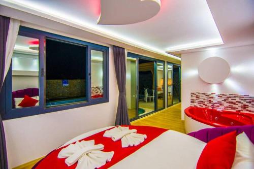 a bedroom with a red and white bed and a television at jakuzili kiralık balayı villası in Kınalı
