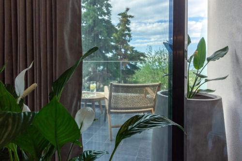 a balcony with a table and a chair and plants at ACRO Upscale Residences in Kórinthos
