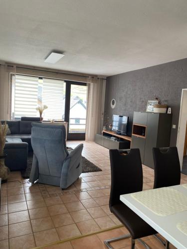 una sala de estar con un sofá, una mesa y sillas en Ferienwohnung Laura, en Bremm