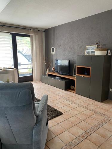 a living room with a chair and a television at Ferienwohnung Laura in Bremm